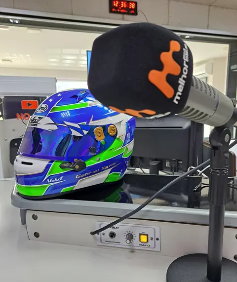 Capacete de Gabriel no estúdio de rádio, ao lado do microfone