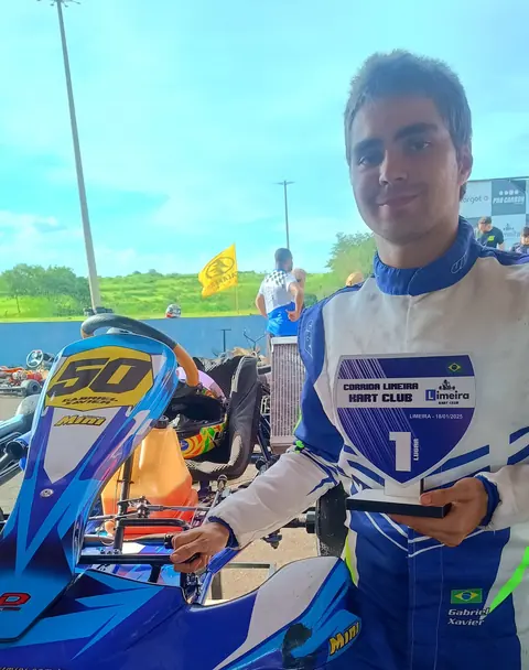 Gabriel com o troféu de 1º lugar ao lado do kart